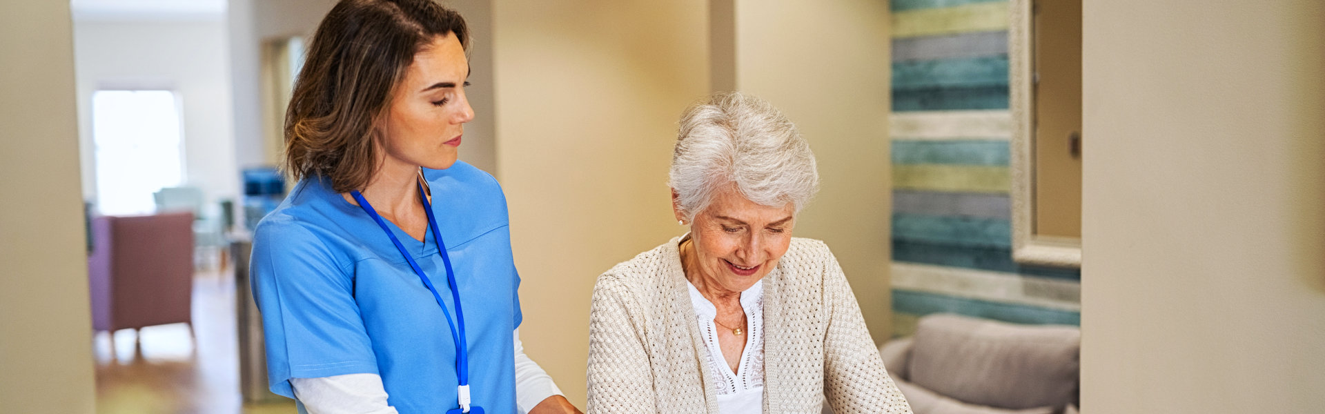 aide assisting an elderly woman in walking